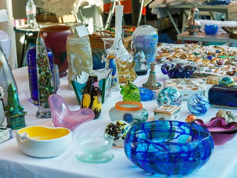 Table displaying colorful glass items for sale.