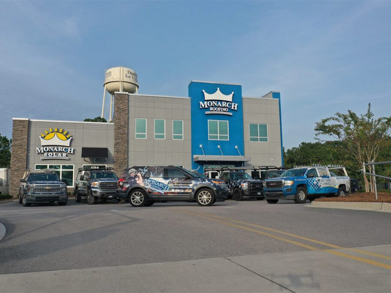 Commercial roofing company building with branded vehicles.
