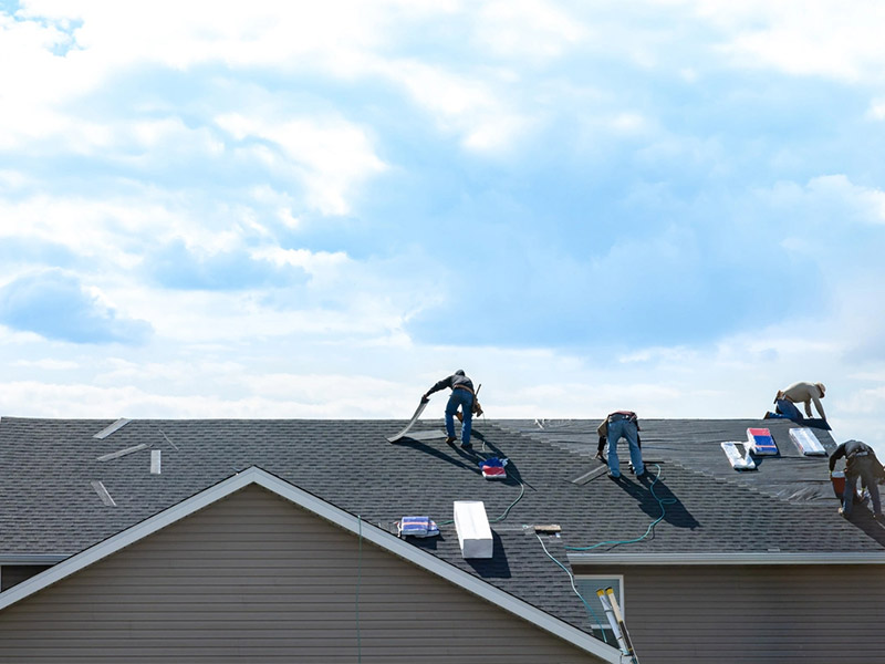 Four workers repairing a residential roof