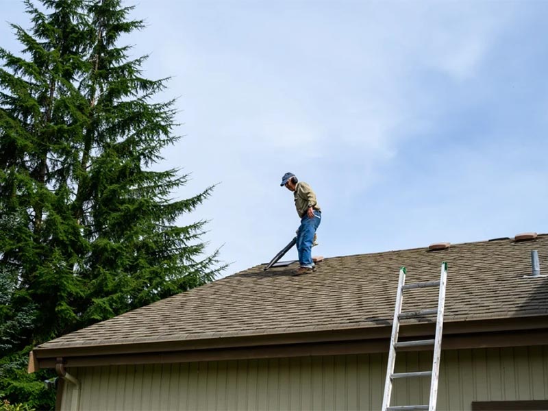 Person preparing to remove roof shingles.