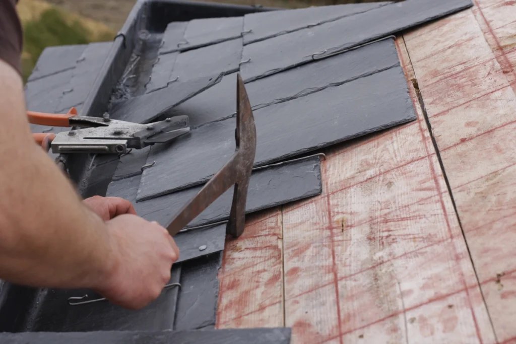 A person is working on a slate roof