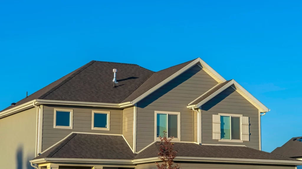 house roof with asphalt shingles against blue sky