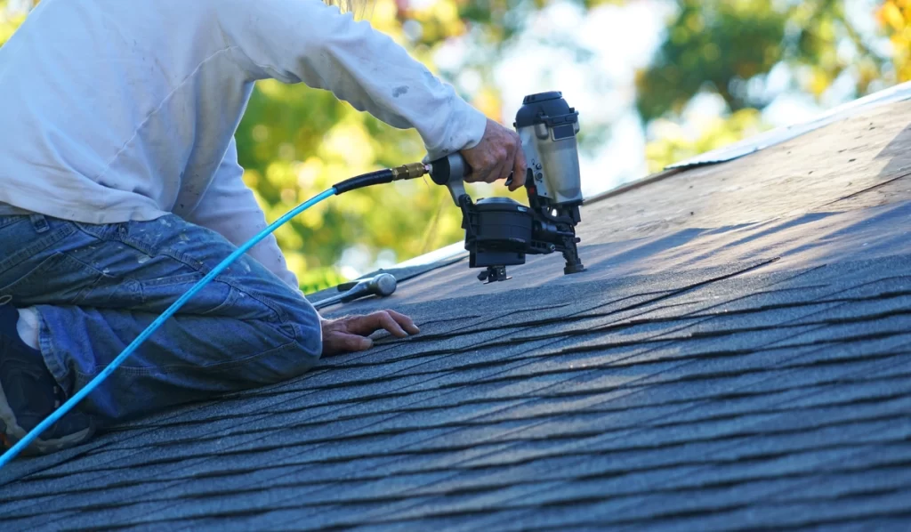 close up of roofing contractor using tools on roof