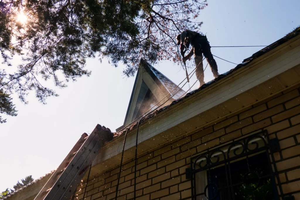 low view of a roofer washing the roof