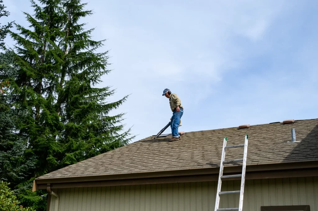 professional roofer inspecting the roof before removing the shingles