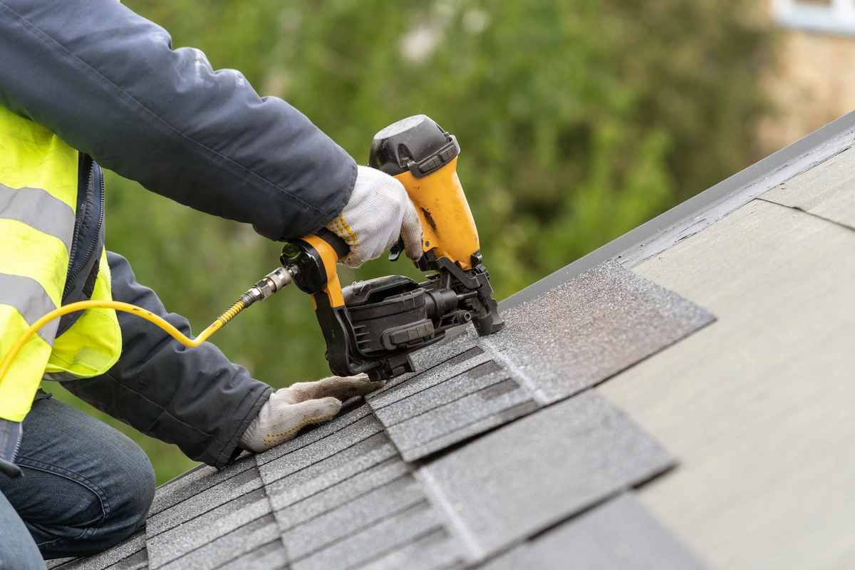 close up to roofer installing new shingles