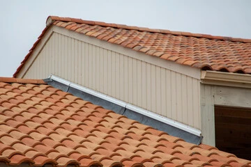 roof flashing between a sloped red roof and a wall