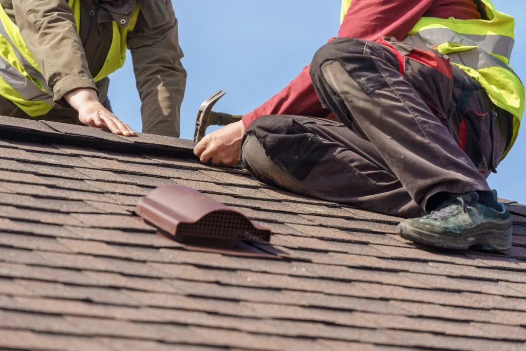 roofer placing a new roof shingle