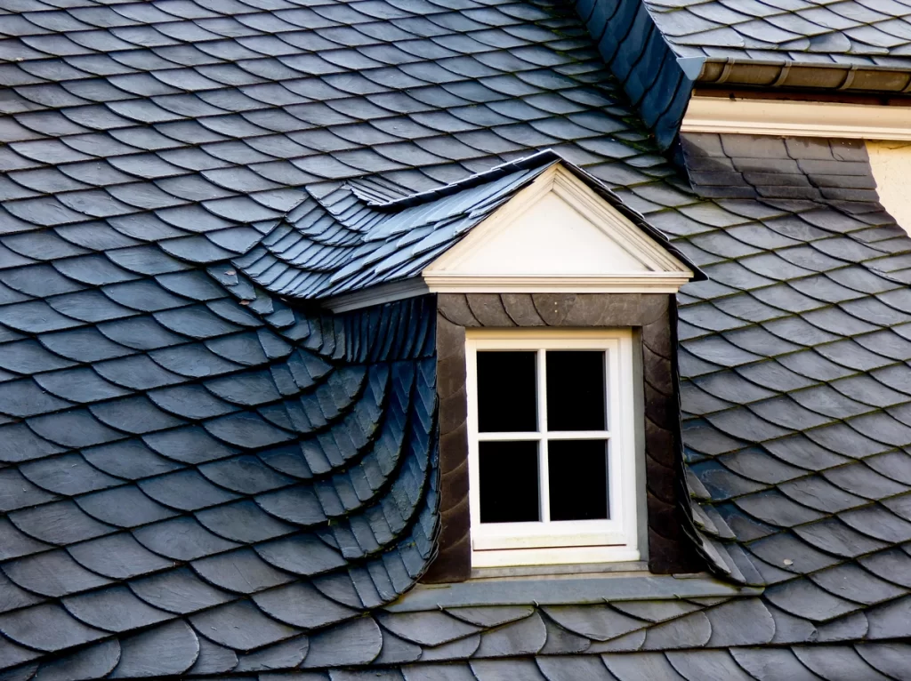 slate roof of a large house with window