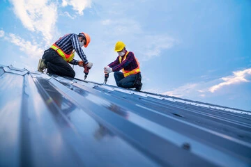 two roof technicians installing metal roof
