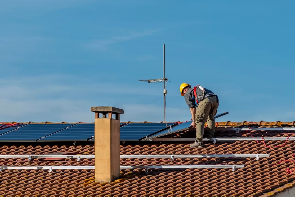 Roofing contractor installs solar panels on roof for energy efficiency