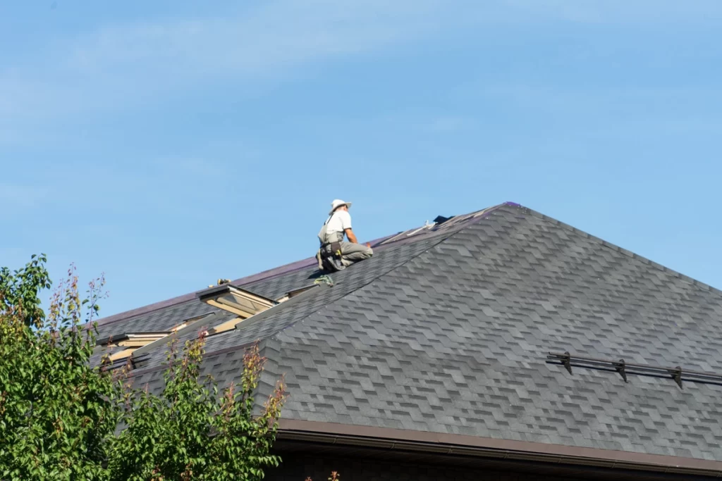 worker replacing shingle roof 