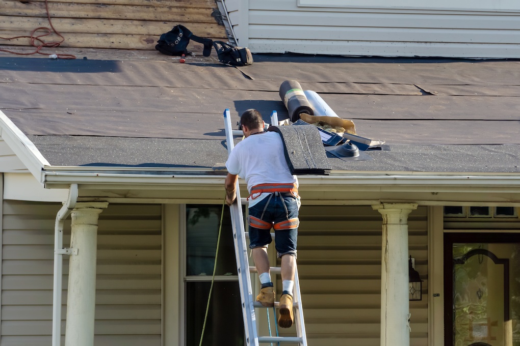 roofing companies wilmington contractor on ladder with shingles